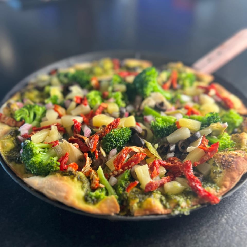 Roca Bar's pizza with broccoli, sun-dried tomatoes, pineapple, black olives, and red onions.